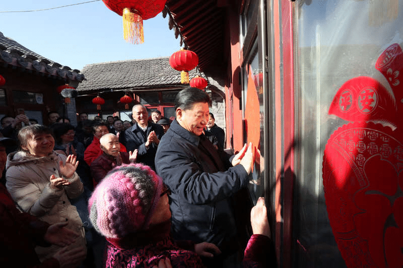 2019年2月1日上午，習近平在北京前門東區(qū)草廠四條胡同32號院，高興地拿起一幅“?！弊?，親自貼到門上，給這里的老街坊們拜年。新華社記者 鞠鵬 攝