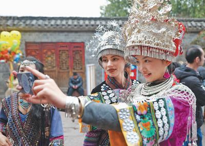 中外游客體驗湘西苗族傳統(tǒng)服飾。 吳東林攝